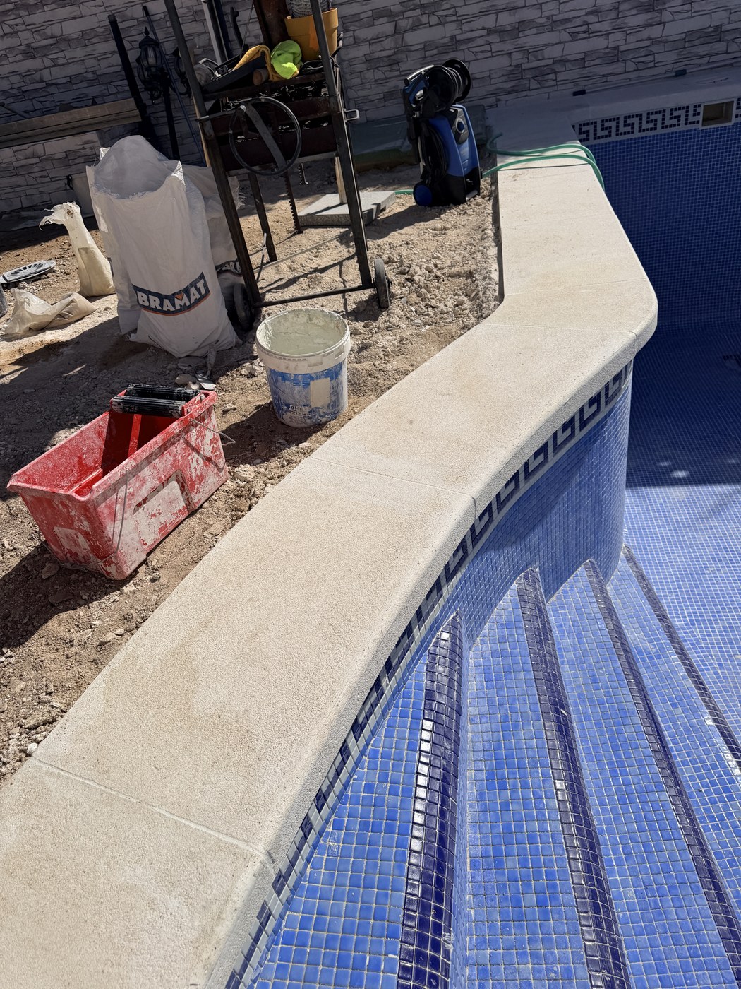 Remate perimetral de piscina en piedra artificial recién colocado